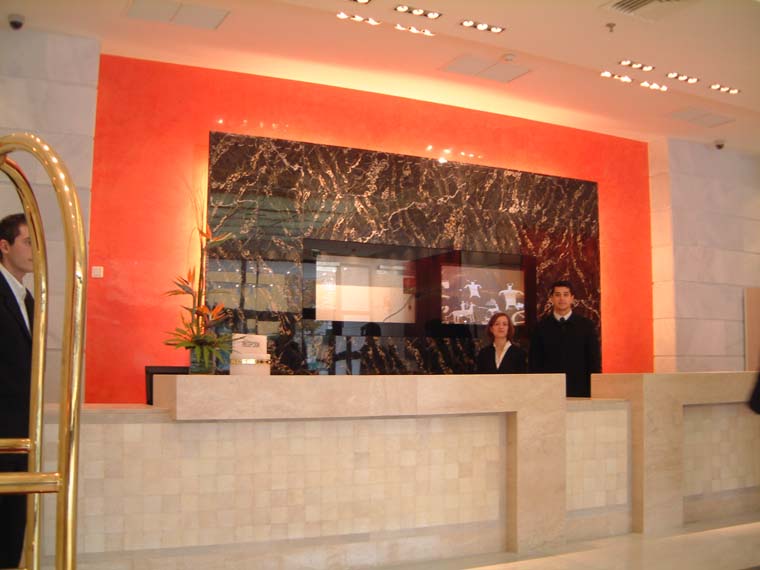 RECEPCION DEL HOTEL GUADALPIN EN MARBELLA. coleccion - luxury hotels -
mostrador en marmol pulido con panelados de galuchat - piel de pescado y tapas de piel de raya.

fondo- estuco veneciano color naranja y panel en marmol portoro con encaje de pantallas de plasma.
lampara en techo de alabastro blanco y laton pulido